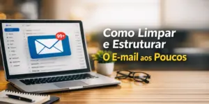 Laptop com tela de e-mail e notificação '99+', bloco de notas e óculos em ambiente de trabalho